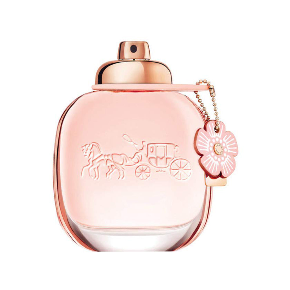 Elegant pink perfume bottle with floral charm and embossed horse-drawn carriage design.